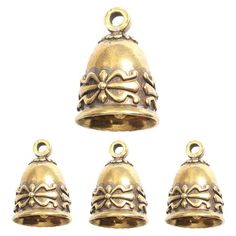 four brass bells with bows on the top and one bell in the middle, set against a white background