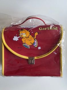 VINTAGE GARFIELD SCHOOLBAG - SHOULDER BAG - HANDBAG Shoulder belt included. From the 80s Rare item New old stock Color: red In its original packaging Fast and reliable shipping in sturdy cardboard boxes. FREE SHIPPING to Europe and the United States.  Additional cost for Track and Trace Please ask any questions prior to ordering and make sure you check all photo's. Note that this is a vintage item and it may have slight imperfections. Item sold as is. Don't forget to check out our other listings and feel free to message us! Retro School Shoulder Bag, Retro Red School Shoulder Bag, Vintage School Satchel Bag, Vintage Satchel Shoulder Bag For School, Vintage Shoulder Bag Satchel For School, Vintage Shoulder Satchel For School, Vintage Rectangular School Bags, Vintage Garfield, Jim Davis