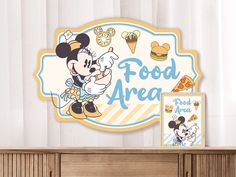 there is a sign that says food area with mickey mouse on it and an image of a cartoon character next to it