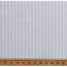 a ruler is next to a white striped wallpaper