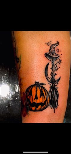 a tattoo with a pumpkin and witch hat on it