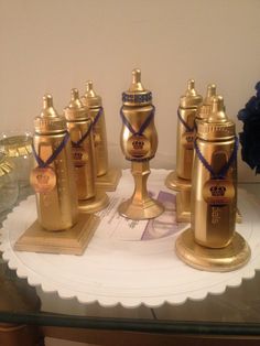 five golden vases are sitting on a glass table