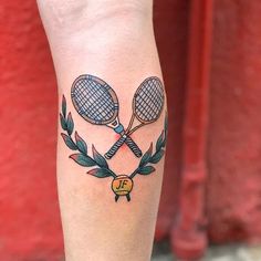 a tattoo on the leg of a person with two tennis rackets