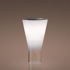 a glass vase sitting on top of a table next to a brown wall and floor