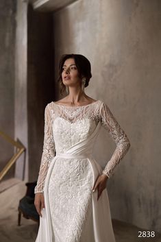 a woman in a wedding dress posing for the camera with her hands on her hips