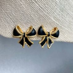 "Vintage Kenneth J. Lane for Avon Black Bow Earrings, Gold Tone Black Enamel Clip on Earrings, Designer Logo KJL Signed Jewelry, Gift for Her. Era: 1986-2000. Designer: K.J.L. for Avon ( Kenneth J. Lane) Measurements: - Length: 1 1/8\" inches. - Width: 1 1/8\" inches. Details: -Metal Color: Gold - Embellishments: Gold Tone Plating , Black Enamel, Ribbon Bow Shaped Earrings. - Closure: Clip On. Here are more Vintage Jewelry items for your viewing pleasure: https://etsy.me/2SGhTFo Our shop team me Gold Clip-on Costume Jewelry Earrings, Vintage Black Clip-on Earrings, Vintage Black Metal Clip-on Earrings, Vintage Enamel Clip-on Earrings, Antique Costume Jewelry, Vintage Jewelry Antique, Vintage Gold Clip-on Earrings With Black Enamel, Mineral Jewelry, Avon Jewelry