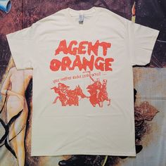 Agent Orange Shirt Unisex Fan Merchandise Shirt With Screen Print, Unisex Screen Print Shirt For Fan Merchandise, Unisex Graphic Print Shirt For Fan Merchandise, Funny Graphic Shirt For Streetwear, Funny Cotton Shirt With Graphic Design, Funny Graphic Design Shirt For Streetwear, Summer Pop Culture Cotton T-shirt, Summer Cotton T-shirt With Pop Culture Style, Orange Graphic Design Tops For Summer