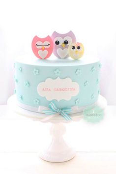 two owls sitting on top of a blue cake