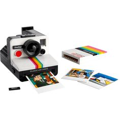 an old polaroid camera sitting on top of a table next to pictures and papers