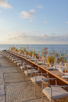 a long table set up on the beach for dinner