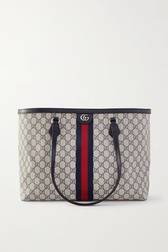 Combining three of Gucci's unmistakable signatures - the interlocking 'GG's, the 'Supreme' motif and the striped webbing - this 'Ophidia' tote is perfect for fans of the label's maximalist approach. It's made from durable coated-canvas with sturdy leather trims and a single zipped pocket inside. The interior is roomy enough for the busiest day. Designer Work Bag, Navy Coat, Gucci Ophidia, Gucci Fashion, Print Coat, Work Bag, Work Bags, Arm Candy, Gucci Dionysus