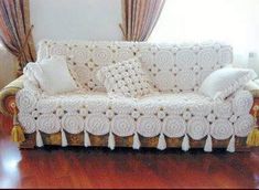 a white couch sitting on top of a hard wood floor next to a wooden table