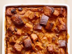 a casserole dish with potatoes and meat in it on a white table top