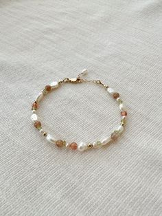 "Please review the bracelet sizing guide below for the perfect fit! This mixed gemstone and pearl beaded bracelet makes a lovely addition to your bracelet stack! The genuine moonstone, sunstone, peridot, and pink pearls are accented by creamy white pearls. Each bracelet is hand beaded to order 🫶🏻 * 2-9mm mixed natural Gemstones and Pearls * 14K Gold Filled or 925 Sterling Silver accents * 14/20 GF 925 stamp for authenticity * Made with all hypoallergenic materials 🤍 * Choose your length. Each bracelet comes with a 1\" extender chain for adjustable sizing. Bracelet Sizing Guide: 5-6.5 inches = xtra small 6.5-7 inches = small 7-8 inches = medium 8 inches+ = large Each Bracelet is measured held taught from tip to end. Unsure what size to choose? The best way to find the right size is to ta Dainty Beaded Bracelets, Dainty Pearl Bracelet, Beaded Bracelet Stack, Sunstone Bracelet, Pearl Beaded Bracelet, Multicolor Bracelet, Peridot Bracelet, Pearls Bracelet, Pearl Bracelets