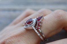 A Swoon-Worthy 2 Piece Bridal Ring Set features a Shimmery Teardrop Faceted 7mm x 5mm Garnet Halo Engagement Ring paired with a Garnet Contour Wedding Band handcrafted in your choice of metal such as Sterling Silver, Rose Plated/Gold Plated Silver or Solid 14k Gold is simply divine! Our Engagement Ring Set will have her swooned as it is a very unique ring set. It comes with a Ring Box ready for gift-giving. Engagement Ring Info ---------------------- Metal: Sterling Silver, Rose Plated/Gold Plat Wedding Pear-shaped Red Ruby Ring, Pear-shaped Ruby Wedding Jewelry, Wedding Pear-shaped Ruby Ring, Elegant Red Bridal Set For Marriage, Red Marquise Cut Ring For Wedding, Red Wedding Rings With Accent Stones, Red Teardrop Wedding Rings, Red Pear-shaped Jewelry For Anniversary, Teardrop Ruby Ring For Wedding