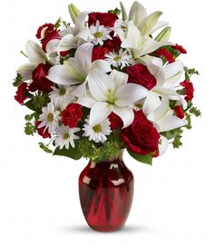 a red vase filled with white and red flowers