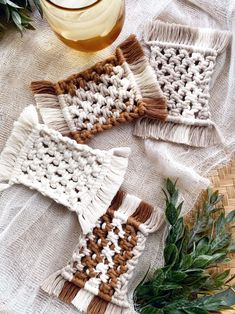 three crocheted coasters sitting on top of a table next to a plant