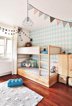 a child's bedroom with two bunk beds and a rug on the wooden floor