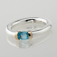 This delightfully hand crafted Sterling silver tension ring makes the ideal choice as a birthstone gift with a mediterranean sea Blue Topaz representing those born in November. The gemstone has a solid gold detail on each shoulder, with the contrasting precious metals enhancing beautifully with the light bright blue of the topaz gemstone. Tension held stones allow the light to reflect the colours without interference from the metalwork. We have been hand making these rings for the last 25 years, Luxury Anniversary Topaz Ring With Bezel Setting, Fine Jewelry Blue Topaz Ring With Tension Setting, Blue Topaz Ring With Tension Setting, Modern Topaz Birthstone Ring As Gift, Modern Topaz Ring As Birthstone Gift, Modern Topaz Birthstone Ring, Modern Topaz Birthstone Jewelry, Modern Round Topaz Birthstone Ring, Modern Topaz Birthstone Ring For Anniversary