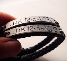 two personalized bracelets with date and year engraved on them in silver or black