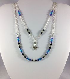 Elegant colors and shining silver accents create a regal style in this multi-strand necklace. This listing is for a two-strand necklace featuring a silver-plated fleur-de-lis charm accompanied by Swarovski beads in blue, black and purple, glass seed beads and silver-plated heishi spacers. The necklace has an ornate silver-plated toggle clasp. The entire length of the necklace is approximately 22 inches long. If you have any questions, feel free to ask me. I will get back to you as soon as I can. Silver Double Strand Necklace, Silver Double Strand Crystal Necklace, Sterling Silver Multi-strand Necklace, Sterling Silver Double Strand Layered Necklace, Elegant Silver Double Strand Crystal Necklace, Silver Layered Double Strand Necklaces, Layered Silver Double Strand Necklaces, Layered Double Strand Silver Necklaces, Layered Silver Double Strand Necklace