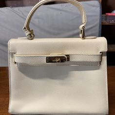 Carbotti Handbags Are Made In Italy. This Cream Color Bag Would Be An Ideal Everyday Medium Sized Purse. Classic Shoulder Bag With Gold-tone Hardware For Shopping, Cream Rectangular Bag With Gold-tone Hardware, Rectangular Cream Bag With Gold-tone Hardware, Timeless Cream Satchel For Formal Use, Elegant Tan Shoulder Bag For Daily Use, Classic Beige Bags For Formal Occasions, Timeless Cream Rectangular Satchel, Classic Beige Formal Bags, Timeless Beige Formal Bag