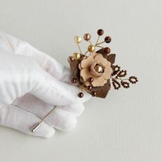 a close up of a person's hand with a flower brooch on it