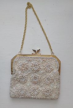 Gorgeous white/champagne AB beaded and sequined  bag with a very intricate design, gold chain handle and creamy satin interior. This beauty has a kiss metal closure.  The interior is in pretty good condition with a few dots and very slight staining.  It features a small pocket.  A few missing beads or sequins but not noticible. Has a tag that says "Hand Made in Hong Kong" Will NOT fit a bigger cell phone but perfect for an ID, lipstick etc. Perfect for that formal event or wedding! 6 inches acro Bead Flower Pattern, White Champagne, Bead Flower, Sequin Bag, Pensacola Fl, Wedding Clutch, Beaded Wedding, White Beads, Intricate Design