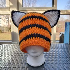 an orange and black knitted hat with ears