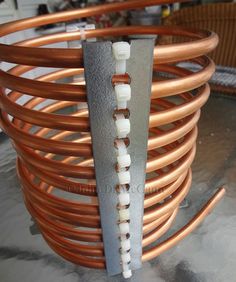 a close up of a coil with wires attached to it and an orange wire in the background