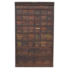 an old wooden filing cabinet with writing on the front and bottom drawers in gold ink