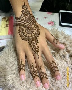 a woman's hand with henna tattoos on it