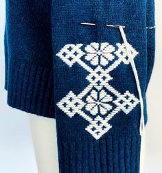 a blue sweater with white designs on it