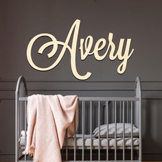 a baby crib with the name avery on it and a blanket in front of it