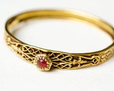 Vintage gold oval hinged bangle bracelet with floral ornate and carnelian in victorian style. Very good vintage condition (some tarnishing and discolouring, please see photos) Ready to ship, gift wrap included. DETAILS: ♥ material: gold tone metal , faux carnelian ♥ approx. size: 7 x 0.25 inch / 18 x 1 cm ♥ style: victorian ♥ unsigned ♥ from smoke-free home Please note that all items in my shop are vintage and may have signs of wear and age including scratches, tarnishing etc. Please see photos Floral Bracelet, Victorian Gold, July Birthstone, Floral Vintage, Hinged Bangle, Gold Floral, Victorian Style, Gold Bangles, Gold Tone Metal