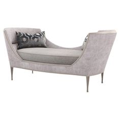 a gray chaise lounge with black and white pillows on the back, in front of a white background