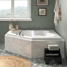 a bathroom with green walls and a white bathtub next to a rug on the floor