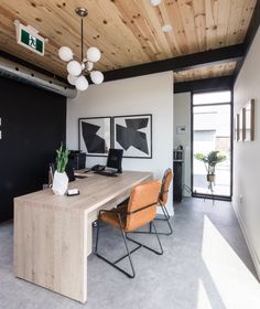 a desk with two chairs and a laptop on it