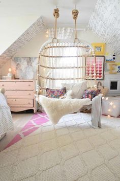 a bedroom with a bed, dresser and hanging hammock in the middle of it