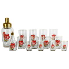 a set of glasses and a bottle with red flowers on the bottom, all in different sizes