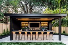 an outdoor bar with several stools in front of it