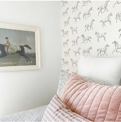 a bedroom with horse wallpaper and bedding in pink, white and grey colors