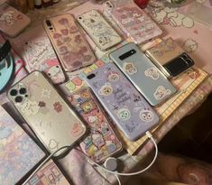 many cell phones are laying on a table with hello kitty stickers all over them