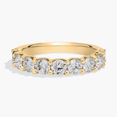 a yellow gold ring with five stones on the side and two rows of diamonds in each band