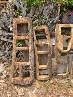 three wooden shelves sitting next to each other in front of a chain link fence and tree