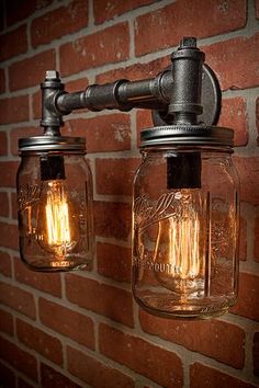 two mason jar lights on a brick wall