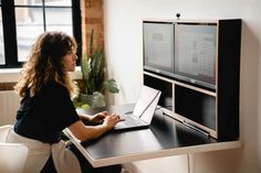 a woman sitting at a desk using a laptop computer