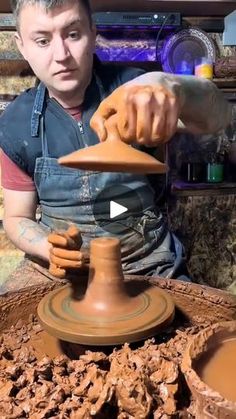 a man working on a pottery wheel with his hands and making it out of clay