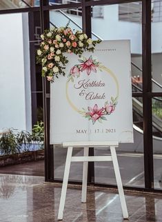 a sign with flowers on it in front of a building