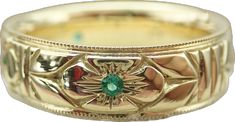 a gold ring with a green stone in the center